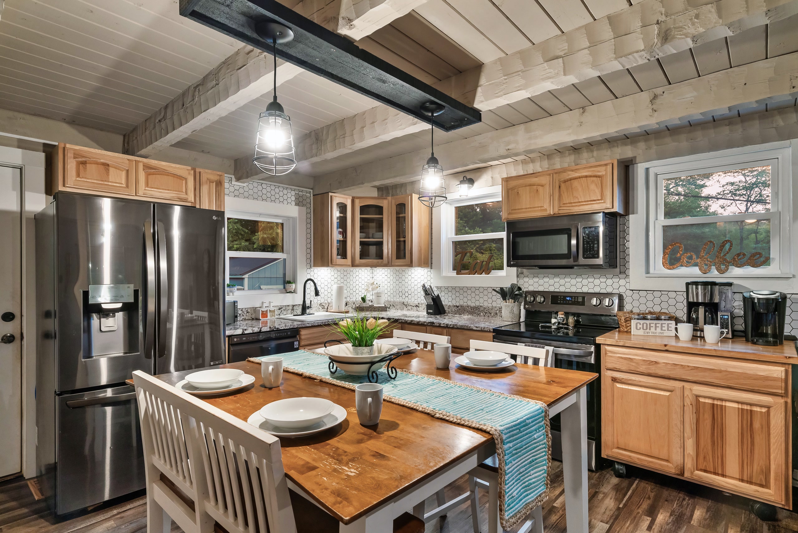 Hillside Haven modern kitchen with wood cabinets and dining table in Tennessee cabin