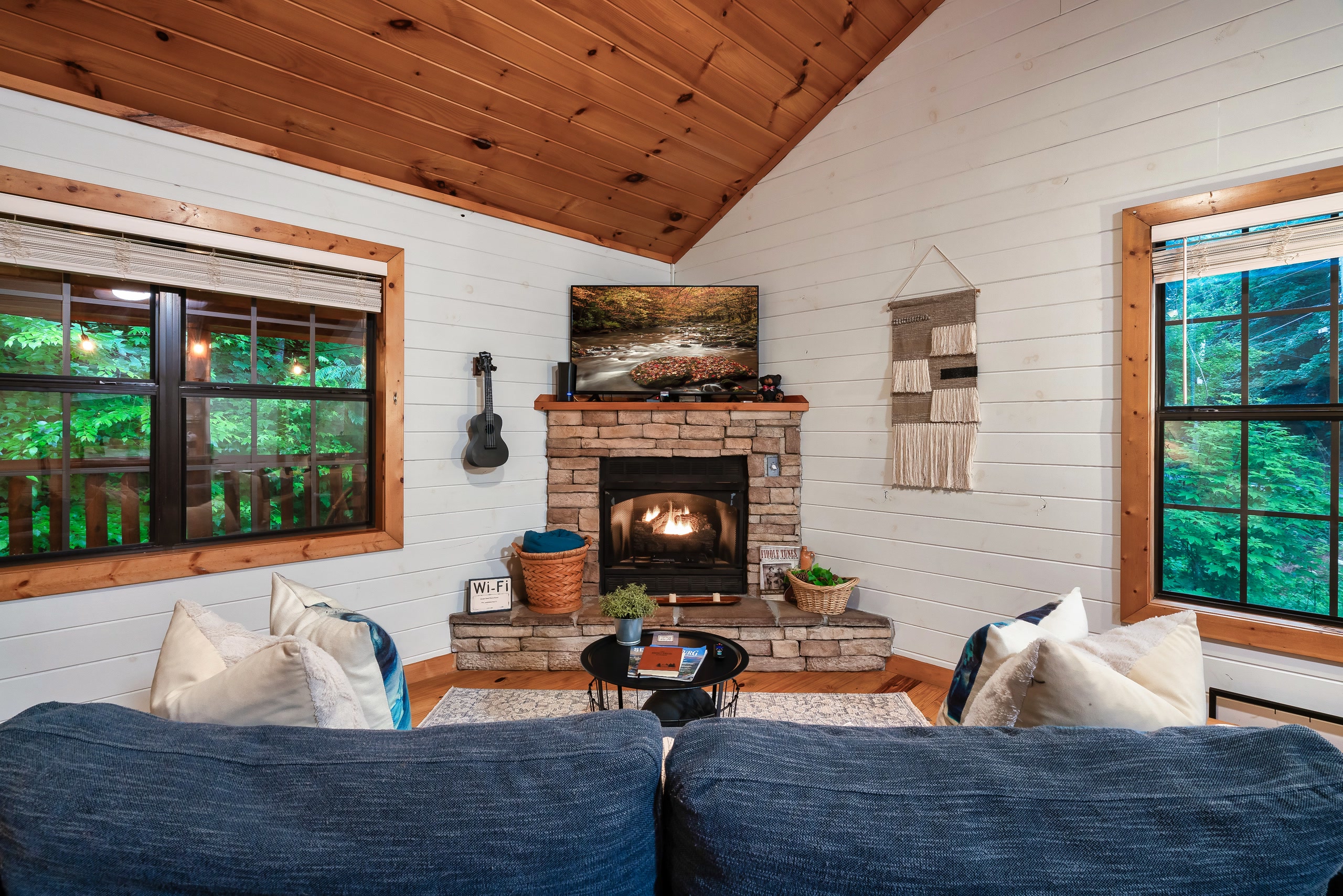 Tennessee cabin living room with stone fireplace and mountain forest views