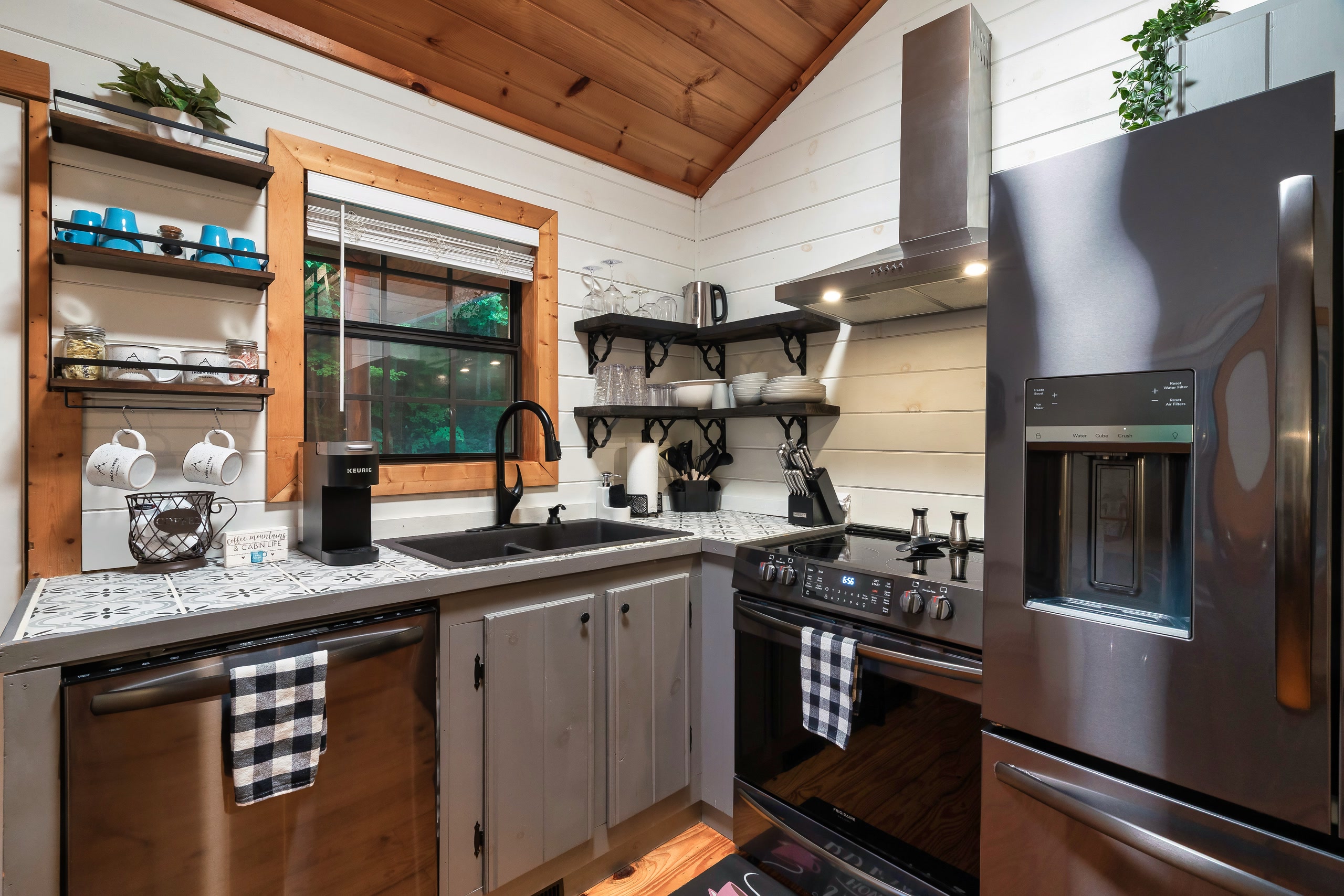Farmhouse kitchen with gray cabinets and black appliances in Tennessee cabin