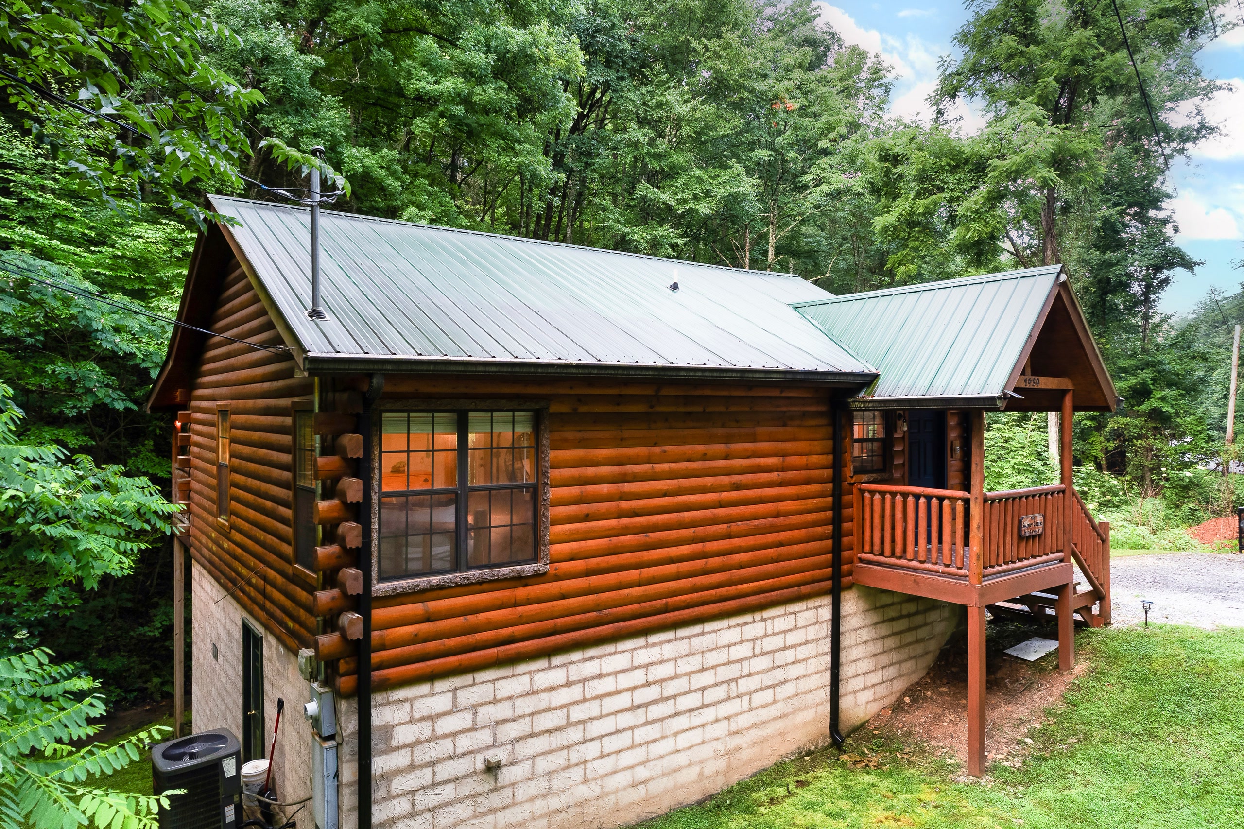 Side exterior of Tennessee log cabin surrounded by mountain forest