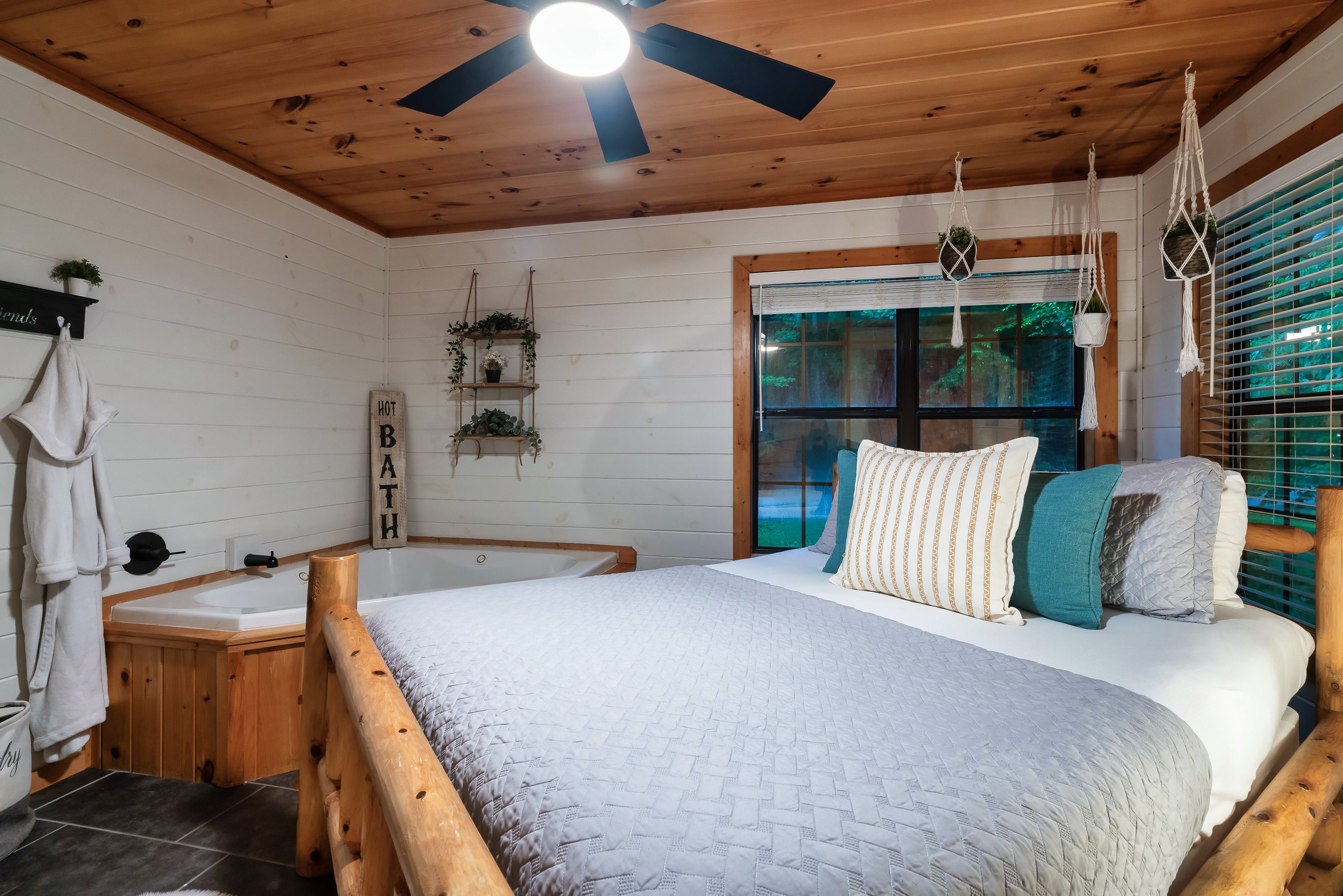 Master bedroom at Smoky Creek Hideaway with corner jetted tub and forest views