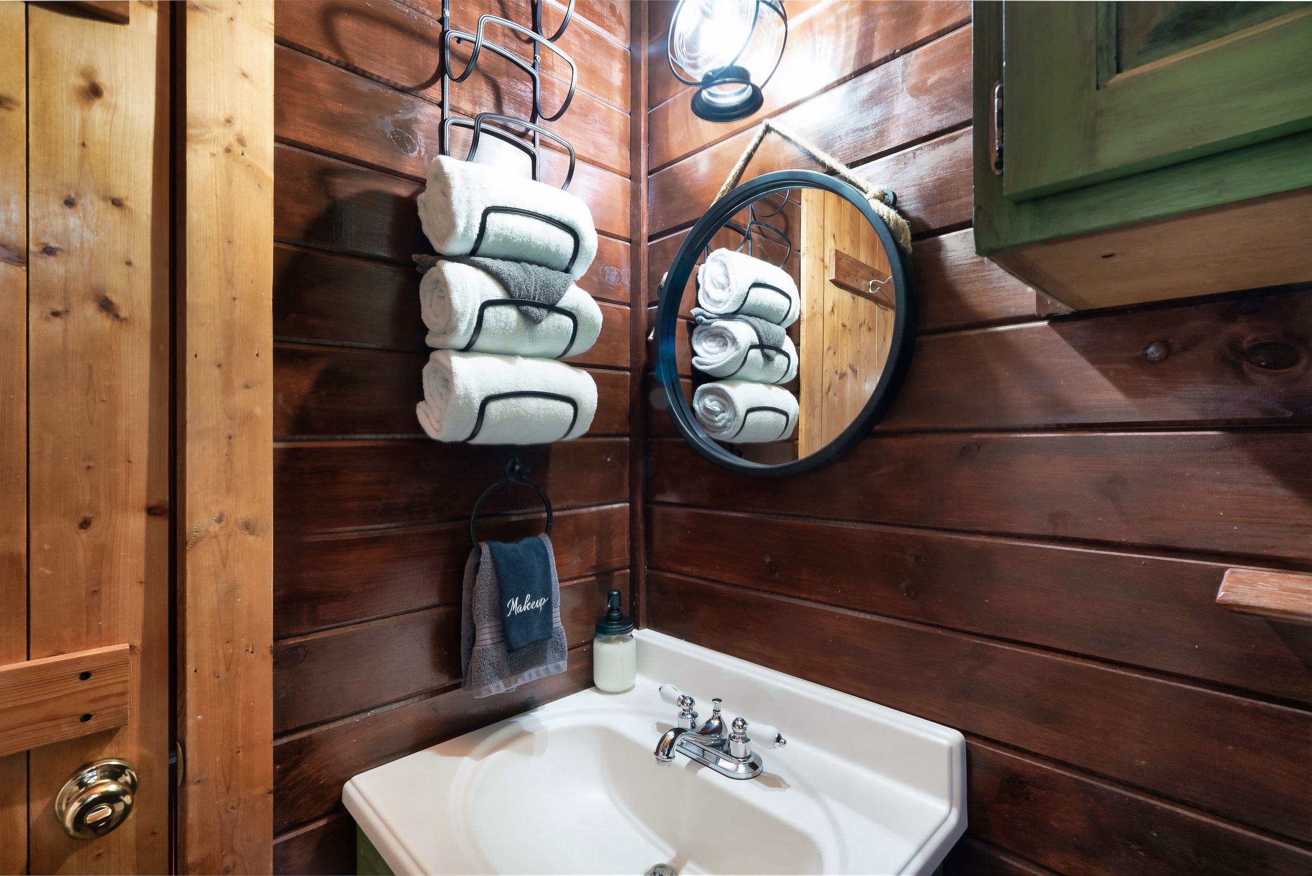 Rustic bathroom with pedestal sink and wood walls at Rustic Rooster