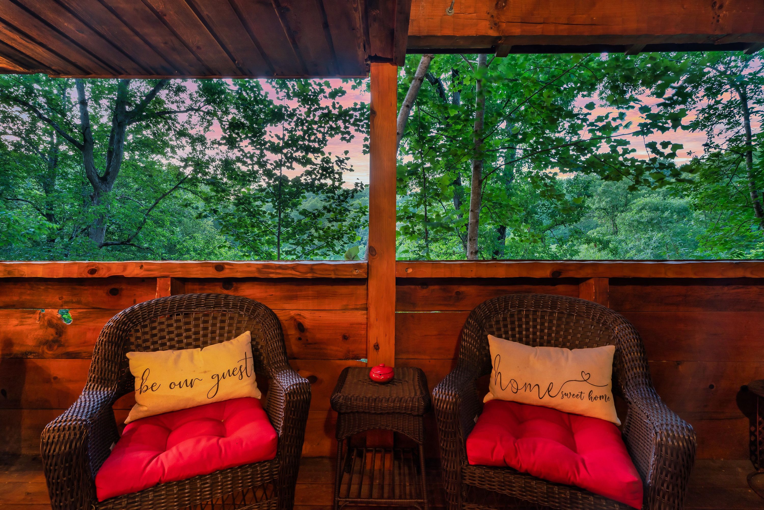 Rustic Rooster deck at sunset with wicker chairs and forest views