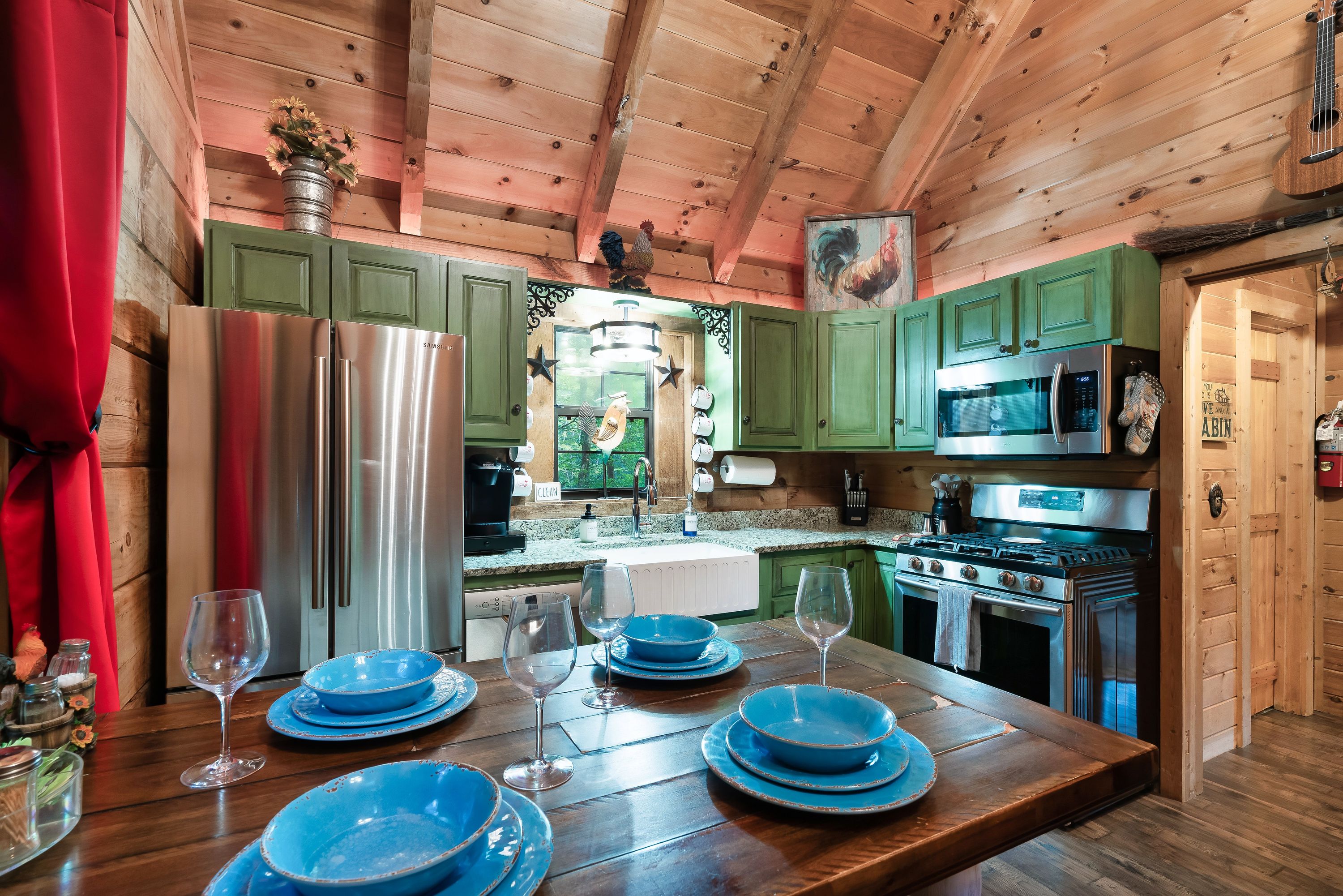 Rustic kitchen with green cabinets and dining table at Rustic Rooster