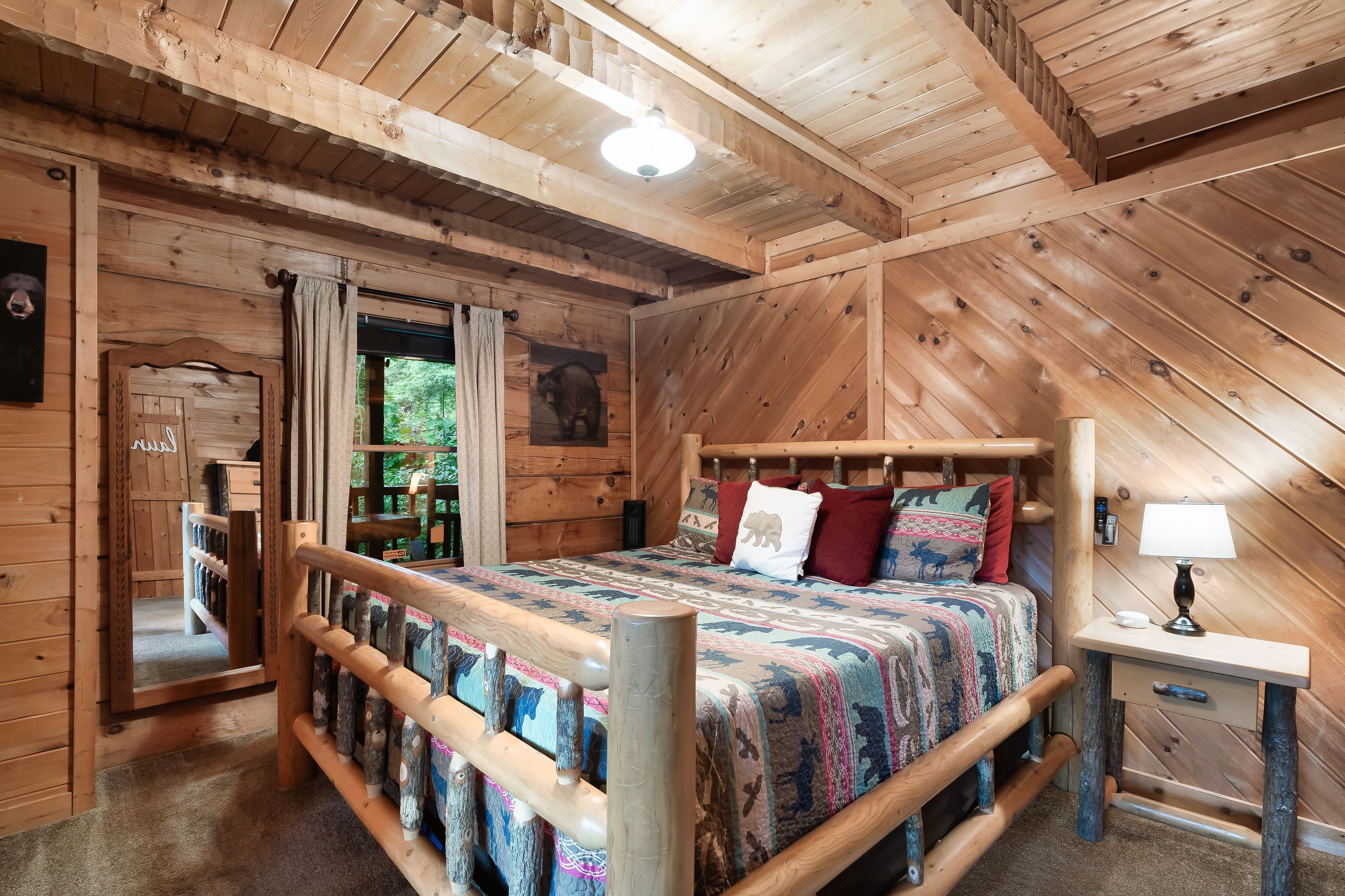 Loft bedroom with log bed frame at Rustic Rooster Tennessee cabin